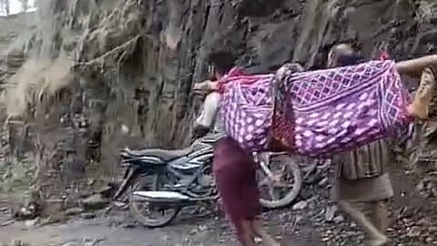 A pregnant tribal woman carried in a cloth sling at Khenda village in Naswadi in Chhota Udepur district