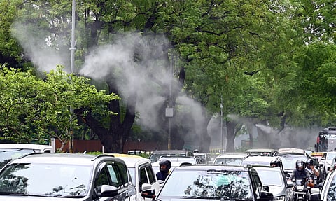 Vehicles pass by mist sprayers installed at Lodhi Road area, in New Delhi, Friday, June 20, 2025.