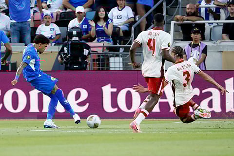 Curacao's Jeremy Antonisse, left, kicks the ball past Canada's Kamal Miller (4) and Zorhan Bassong (3) to score in the open net during a CONCACAF Gold Cup soccer match Saturday, June 21, 2025, in Houston, Texas.