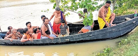 Residents of a flooded village are travelling on a boat in the Balasore district