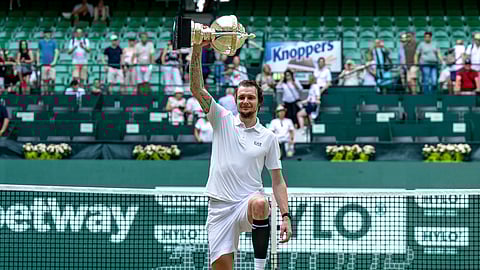 Kazakhstan's Alexander Bublik holds the trophy after defeating Russia's Daniil Medvedev in their men's single final of the Halle tennis tournament, Germany, Sunday, June 22, 2025.