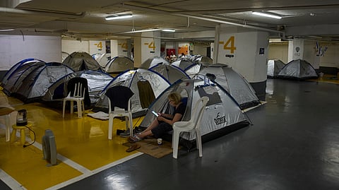 People spend the night in an underground parking garage as a precaution against possible Iranian missile attacks, in Tel Aviv, Israel, Monday, June 23, 2025.