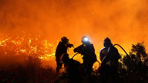 Firefighters battle with a large wildfire burning in Kofinas, on the eastern Aegean island of Chios, Greece, late Sunday, June 22, 2025.