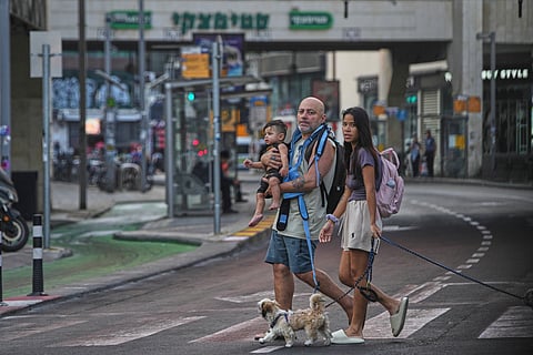 People leave an underground parking garage where they took shelter after an air raid alarm of Iranian missile attacks went off, in Tel Aviv, Israel, Tuesday, June 24, 2025.