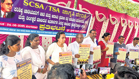 Activists and members of the SC communities hold posters and protest in Freedom Park on Tuesday.
