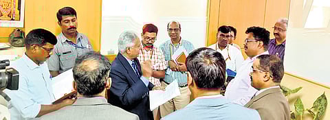 Lokayukta Justice BS Patil (centre - in dark blue suit) speaks to officials during a visit to the KSPCB head office in Bengaluru on Wednesday