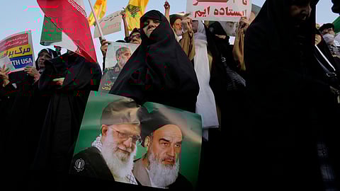 An Iranian woman holds a poster of the late revolutionary founder Ayatollah Khomeini, right, and Supreme Leader Ayatollah Ali Khamenei in an anti-U.S. and anti-Israeli rally at Enqelab-e-Eslami (Islamic Revolution) square in downtown Tehran, Iran, Tuesday, June 24, 2025
