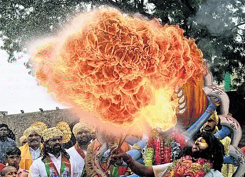A performer breathes fire during Bonalu at Sri Jagadamba Mahankali temple, Golconda