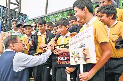 Home Minister Dr G Parameshwara greets students at an International Day Against Drug Abuse and Illicit Trafficking event in Bengaluru on Thursday
