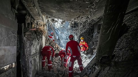 In this photo taken Tuesday, June 24, 2025, rescuers search through the rubble of a damaged section of Evin Prison following an Israeli strike the day before, in Tehran, Iran.