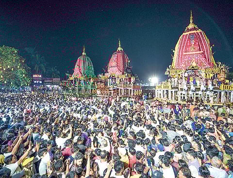 Devotees gather in large numbers outside the Shree Gundicha temple to get a glimpse of the three deities atop their grand chariots, at Puri on Saturday | SJTA