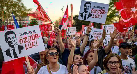 Protesters hold Turkish flags and placards reading 'Freedom for Imamoglu' as they take part in a demonstration against the detention of the Mayor of Istanbul, Ekrem Imamoglu, organised by the country's main opposition, the Republican People's Party (CHP), at Beyazid Square, in Istanbul, 07 May 2025.