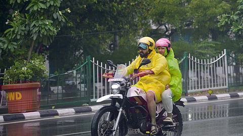 Biker riding with Rain coat as monsoon reaches in Delhi.