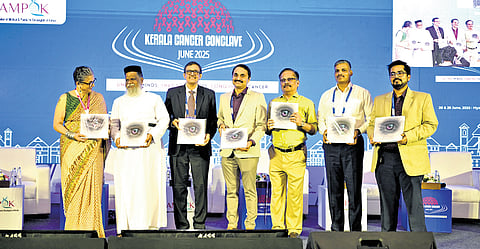 Viji Venkatesh (Regional Head - India & South Asia, The Max Foundation),
Rev Fr M C Poulose (CEO, Parumala Hospital), Dr Narayanankutty Warrier, Medical Director of MVR Cancer Centre and Research Institute, Dr Boben Thomas, Secretary of AMPOK, Dr S P Asokan (Chairman, S P Fort Hospital), Col. M S Navalgatti (Director, ECHS) and souvenir’s Editor, Dr Ashok S Komaranchath with the souvenir magazine at the Kerala Cancer Conclave 2025