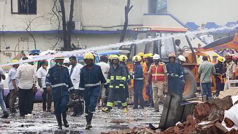 Firefighters and emergency services personnel inspecting the site.