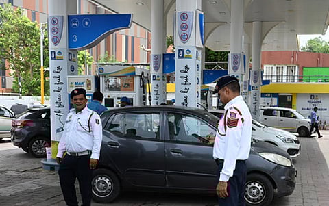 Traffic Police personnel keep a vigil at a petrol pump after fuel ban for end-of-life vehicles