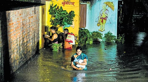 A woman vacating her house near Badagada market after heavy rains flooded Badagada canal road area.