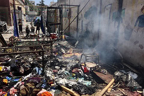 Children look at smouldering debris at Mustafa Hafez school, sheltering Palestinians displaced by the war, following an overnight Israeli strike in Gaza City, on July 3, 2025, amid the ongoing conflict between Israel and the Palestinian Hamas militant group.