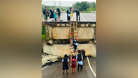 Children studying in Catherine School have to take the challenge of scaling the 25-foot ladder every day to reach their school after the Pelol bridge collapsed after incessant rains.