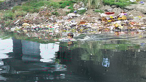 A boy baths in black waters under the Old Yamuna Bridge in Delhi.