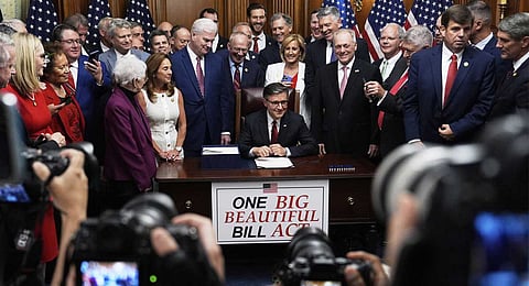 Speaker of the House Mike Johnson, R-La., surrounded by Republican members of Congress, signs President Donald Trump's signature bill of tax breaks and spending cuts, Thursday, July 3, 2025, at the Capitol in Washington.