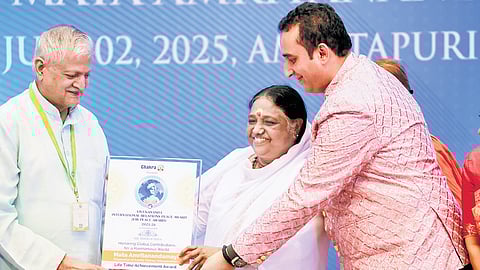 Vivekananda International Relations representatives hand over plaque and commendation certificate to Mata Amritanandamayi Devi on Friday.