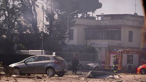 Firefighters work as smoke rises after a gas station exploded on the outskirts of Rome, Friday, July 4, 2025.