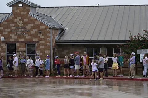 Families line up at a reunification center after flash flooding it the area, Friday, July 4, 2025, in Ingram, Texas.