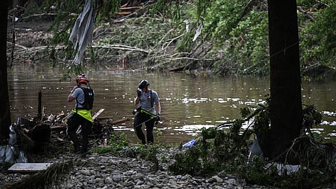 Members of a search and rescue team look for people near Camp Mystic, the site of where at least 20 girls went missing after flash flooding in Hunt, Texas, on July 5, 2025.