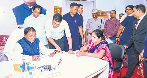CM Mohan Charan Majhi takes note of the grievance of a woman, in Bhubaneswar
