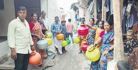 Villagers protest with empty pots at gram panchayat office.