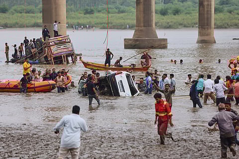 Rescuers and locals look for survivors after several vehicles fell into a river following the collapse of a portion of a bridge in Mujpur near Vadodara in the Indian state of Gujarat, Wednesday, July 9, 2025