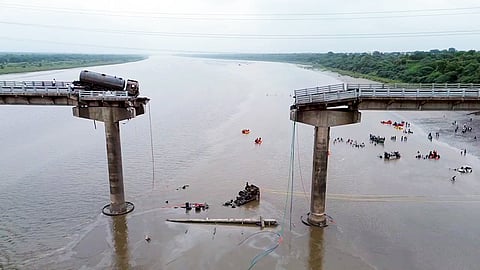 A truck hangs loosely from the Gambhira bridge on the Mahisagar river connecting Vadodara and Anand, which collapsed on Wednesday, July 9, 2025.