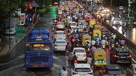 Vehicles move through a waterlogged road amid traffic jam after rain at ITO, in New Delhi on July 9.