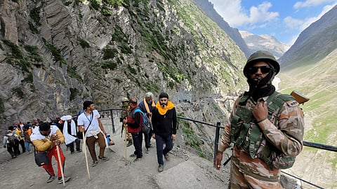 In this July 3, 2025, photo, security personnel stand guard as pilgrims arrive during the 2025 Amarnath Yatra in Ganderbal.