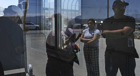 People wait outside of Glass House Farms, a day after an immigration raid on the facility, Friday, July 11, 2025, in Camarillo, Calif.