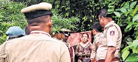 Police personnel confront Russian woman Nina Kutina, who lived with her children in a cave in Gokarna