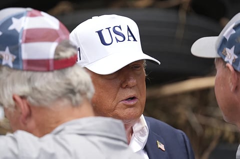 President Donald Trump, center, greets first responders as he observes flood damage in Kerrville, Texas, Friday, July 11, 2025.