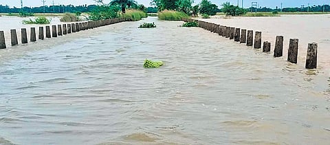 Floodwater flowing over a road in Aul block of Kendrapara district.