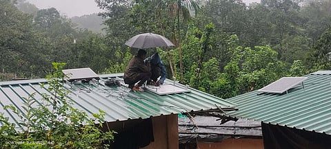 Volunteers installing Solar solar-powered electricity connection to the tribal houses at the Designkudi tribal hamlet in Valparai.