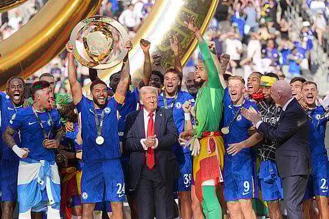 Chelsea's Reece James (24) lifts the trophy as President Donald Trump looks on following the Club World Cup final soccer match between Chelsea and PSG in East Rutherford, N.J., Sunday, July 13, 2025.