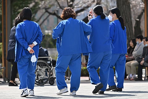 Medical workers walk outside a hospital in Seoul