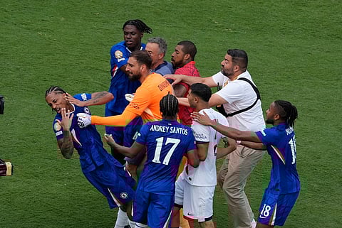 Chelsea's Joao Pedro, left, is attacked by Paris Saint-Germain's goalkeeper Gianluigi Donnarumma and coach Luis Enrique at the end of the Club World Cup final soccer match between Chelsea and PSG on July 13, 2025.