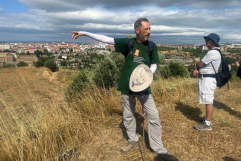 Jesuit Josep LluÌs Iriberri points toward Manresa, where his group of pilgrims will conclude the Ignatian Way pilgrimage, in Spain, Wednesday, July 9, 2025.