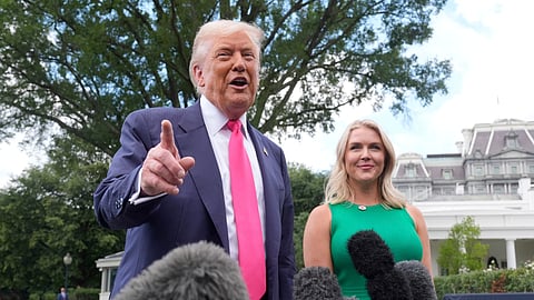 US President Donald Trump speaks to the media as he leaves the White House, Tuesday, July 15, 2025, in Washington, as White House press secretary Karoline Leavitt, looks on.