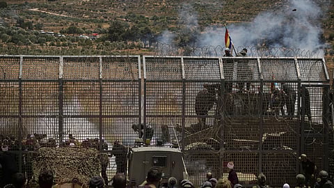 Syrian Druze protest near the Israeli-Syrian border, as seen from the town of Majdal Shams in the Israeli-occupied Golan Heights, Wednesday, July 16, 2025, amid the ongoing clashes between Syrian government forces and Druze armed groups in the southern Syrian city of Sweida.