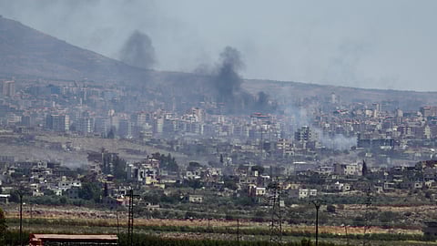 Smoke rises from clashes between Syrian government forces and Druze militias in Sweida city, southern Syria, Tuesday, July 15, 2025.