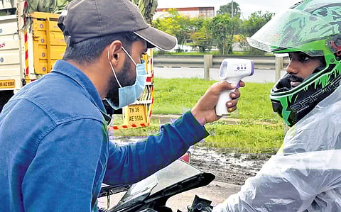 Passengers from Kerala being checked by Tamil Nadu health authorities at the state border on Wednesday