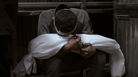 Hossam Azzam holds the body of his child, Amir, who was killed in an Israeli military airstrike on Gaza, at Shifa Hospital in Gaza City Tuesday, July 15, 2025.