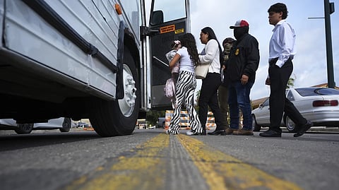 A family from Colombia is detained and escorted to a bus by federal agents following an appearance at immigration court Monday, July 14, 2025, in San Antonio.